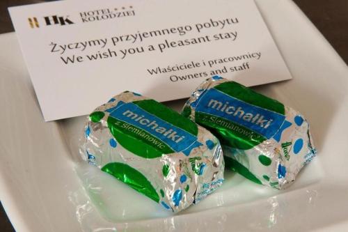 two chocolate wrappers on a plate with a card at Albergo KOLODZIEJ in Siemianowice Śląskie