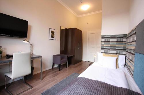 a hotel room with a bed and a desk and a tv at Albergo KOLODZIEJ in Siemianowice Śląskie