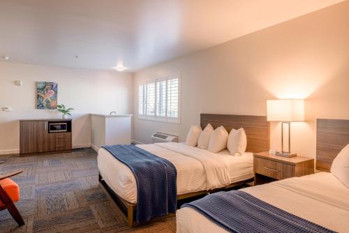a hotel room with two beds and a table at Inn At Moss Landing Point in Moss Landing