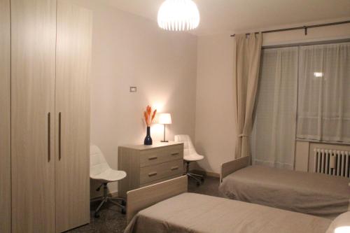 a bedroom with two beds and a dresser and a desk at Affittacamere Nansen in Rome