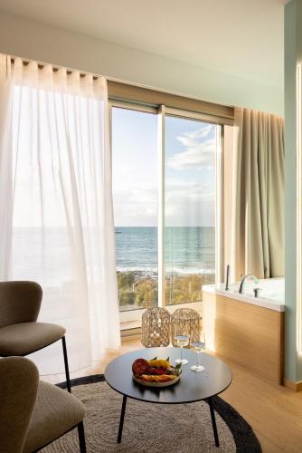 a living room with a table and a view of the ocean at Metamare in Cozze