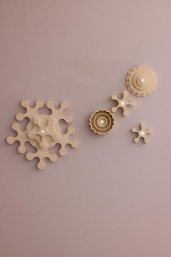 three pieces of wooden gears on a white background at Metamare in Cozze
