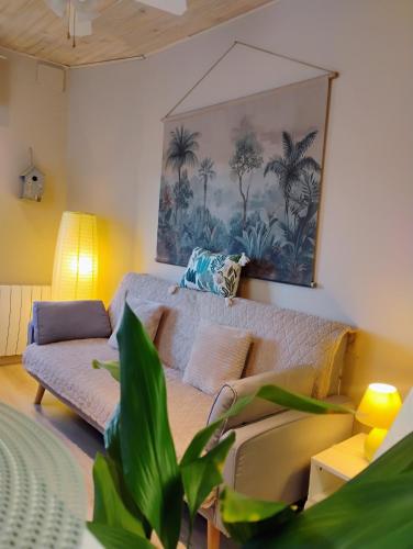 un salon avec un canapé et un tableau au mur dans l'établissement Gîte Le Marronnier - au calme - parking & terrasse - près de Colmar et Riquewihr - route des vins, à Châtenois