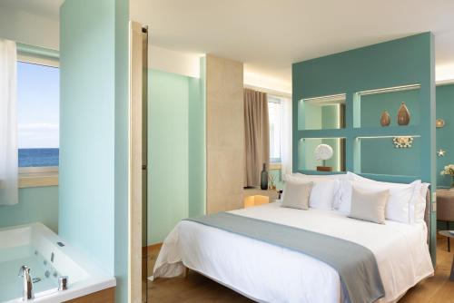 a bedroom with a large bed and a blue wall at Metamare in Cozze