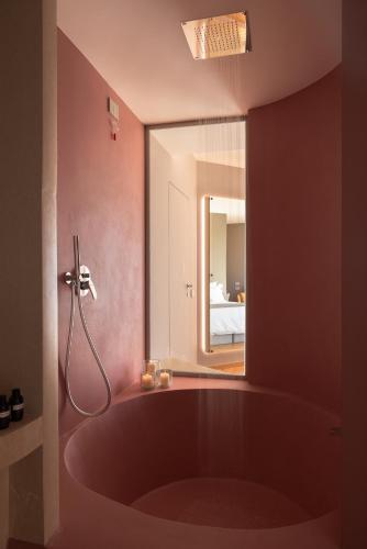 a red bath tub in a bathroom with a mirror at Metamare in Cozze