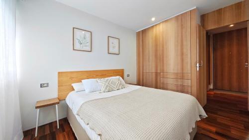 a bedroom with a large bed and a wooden cabinet at Desconectaengalicia Rincón de Cabodeiro in Isla de Arosa