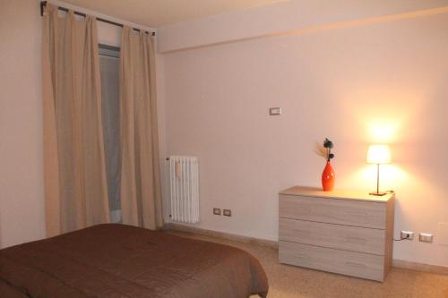 a bedroom with a bed and a dresser with a lamp at Affittacamere Nansen in Rome