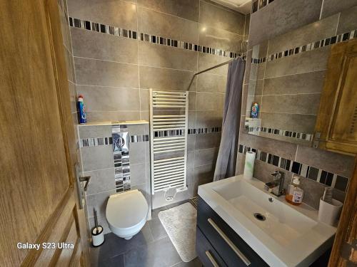 une salle de bain avec des toilettes blanches et un lavabo dans l'établissement Maison entre Paris et Disney, stade nautique olympique Vaires sur marne, à Pontault-Combault