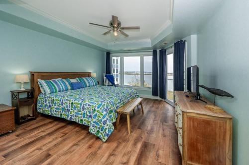 a bedroom with a bed and a television in it at Sunset Bay Villa 221 - Waterfront, Pool, Gym! in Chincoteague