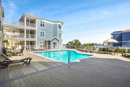 a swimming pool on a deck next to a building at Sunset Bay Villa 221 - Waterfront, Pool, Gym! in Chincoteague