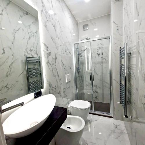 a bathroom with a sink and a shower and a toilet at House 21 Residence Room in Collecchio