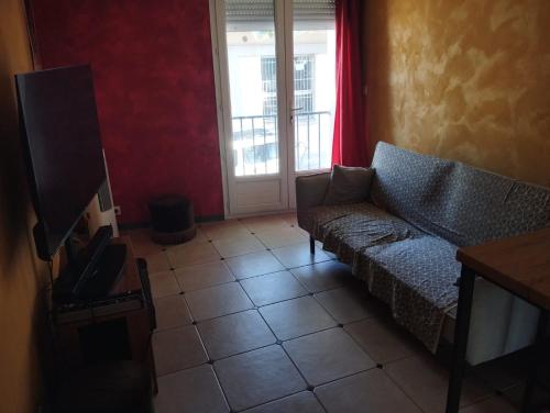 a living room with a couch and a television at Maison 2 faces Argeles Centre Ville in Argelès-sur-Mer