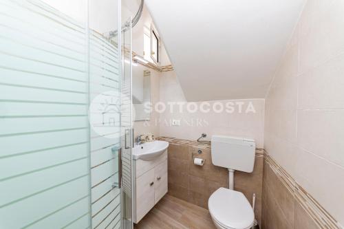 un baño con inodoro y lavabo en LORY'S HOUSE, en Porto Cesareo