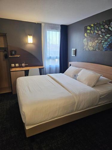 Ein Bett oder Betten in einem Zimmer der Unterkunft Kyriad Niort-Espace MendesFrance