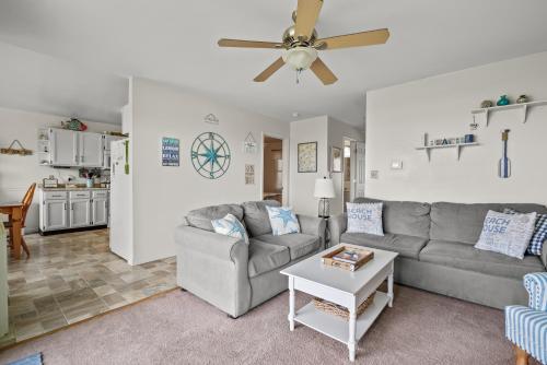 a living room with a couch and a ceiling fan at Sunset Dreams - Pet friendly, Waterfront, & shared dock! in Black Point Landing