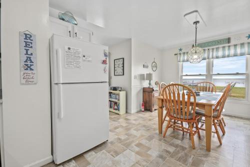 a kitchen and dining room with a refrigerator and a table at Sunset Dreams - Pet friendly, Waterfront, & shared dock! in Black Point Landing