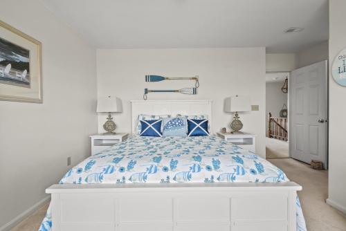 a bedroom with a bed with a blue and white comforter at Sunset Dreams - Pet friendly, Waterfront, & shared dock! in Black Point Landing