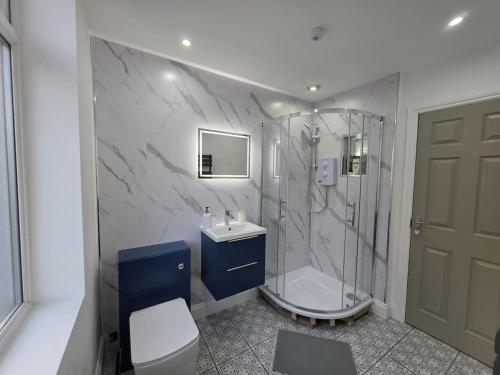 a bathroom with a shower and a toilet and a sink at 18 Anfield 5 min walk Sleeps 7 4BR 5Bed 3Bathrms in Liverpool