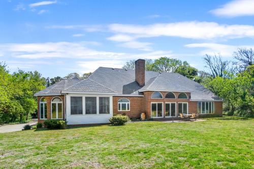 a brick house with a chimney on top of a yard at Sunset on the Rocks - Luxurious beachfront comfort! in Cape Charles