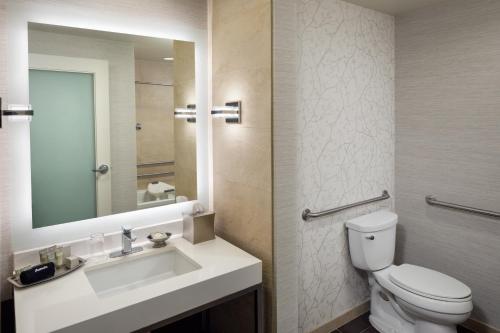 a bathroom with a sink and a toilet and a mirror at The Hotel at Arundel Preserve in Hanover
