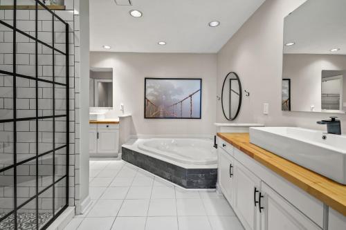 a bathroom with two sinks and a bath tub at Sunset on the Rocks - Luxurious beachfront comfort! in Cape Charles