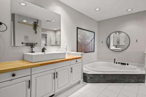 a white bathroom with a tub and a sink at Sunset on the Rocks - Luxurious beachfront comfort! in Cape Charles