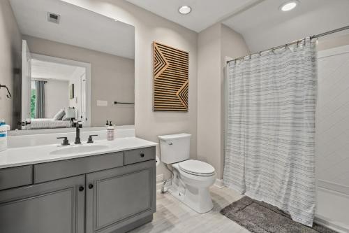 a bathroom with a toilet and a sink and a shower at Sunset on the Rocks - Luxurious beachfront comfort! in Cape Charles