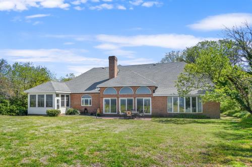 a home with a brick house with a lawn at Sunset on the Rocks - Luxurious beachfront comfort! in Cape Charles