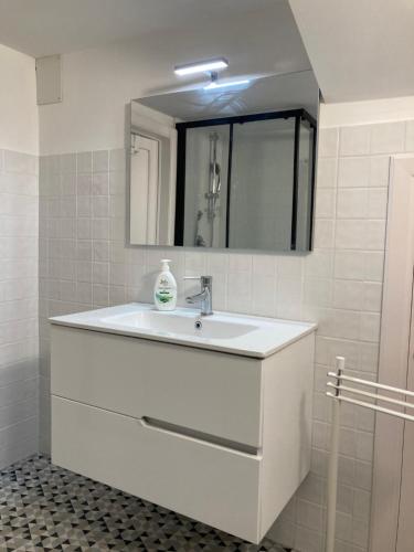 a white bathroom with a sink and a mirror at Casa Makarina Appartamento con Cucina in Mazzarino