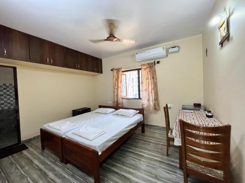 a small room with a bed and a table at D 'SOUZA HOLIDAY HOME in Benaulim