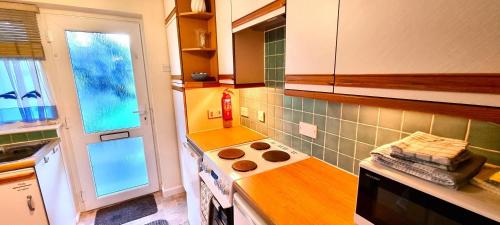 a kitchen with a stove top oven next to a window at 9 Wheal Ramoth in Perranporth
