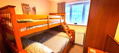 two bunk beds in a room with a window at 9 Wheal Ramoth in Perranporth
