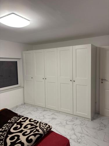 a bedroom with white cabinets and a flat screen tv at Flughafen in Braunschweig