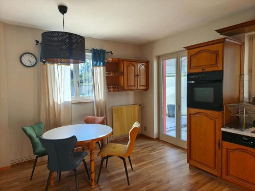 une cuisine avec une table et des chaises ainsi qu'une salle à manger dans l'établissement Le Nid des Loups, à Abreschviller