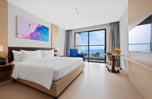 a hotel room with a bed and a large window at The Mango - Arena Cam Ranh Beachfront Resort - 5 Star in Cam Ranh International Airport