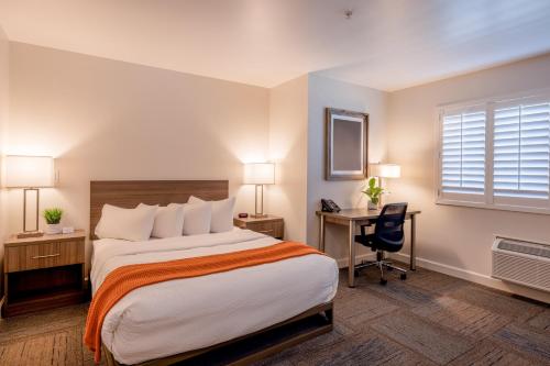 a hotel room with a bed and a desk and a window at Inn At Moss Landing Point in Moss Landing