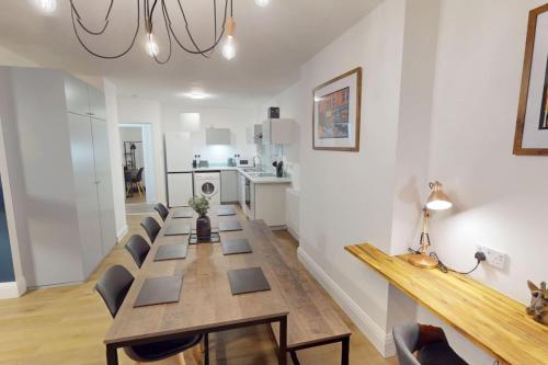 a dining room with a long table and chairs at 3BR, song lyrics theme, self check-in in Manchester