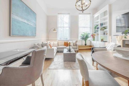 a living room with a couch and a table at 2BR, garden, 60" TV with sound system in London