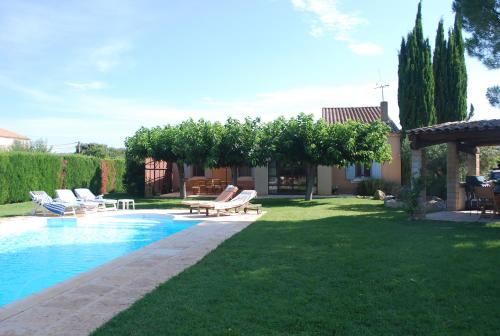 une cour avec une piscine et des chaises longues dans l'établissement Provencal villa, Luberon Park, à Maubec