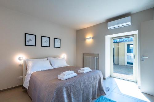 グルメッロ・デル・モンテにあるLove Italy Homes - Il Borghetto Suiteのベッドとタオル2枚のある寝室