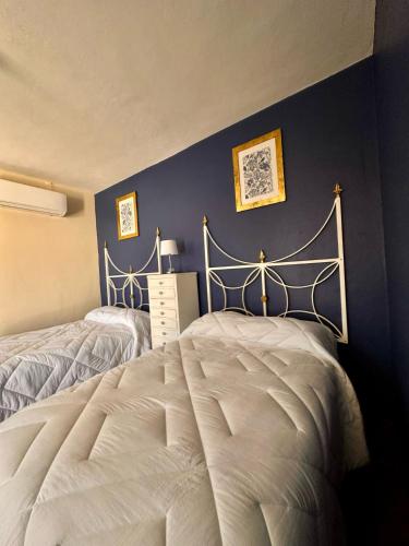 a bedroom with two beds and a blue wall at Hotel Nikché Mérida in Mérida