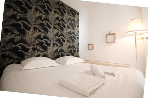 - une chambre avec un lit blanc et du papier peint noir et blanc dans l'établissement JULES GREC Appartement Loggia Piscine et Confort à Antibes, à Antibes