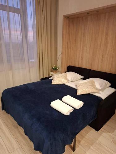 a large blue bed with two white towels on it at Zlatarooms in Warsaw