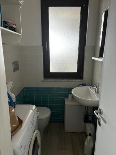 a bathroom with a sink and a toilet and a window at Sunsea House Copanello in Copanello