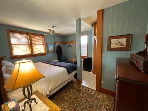 a bedroom with a bed and a lamp in a room at Blackbird Glen Bed and Breakfast, Glenmore, Kelowna, BC in Kelowna