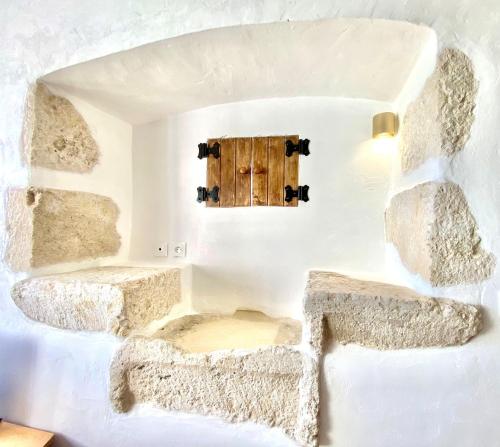 a room with two stone benches and a wooden door at Petit Gîte de Calvet in Sainte-Croix