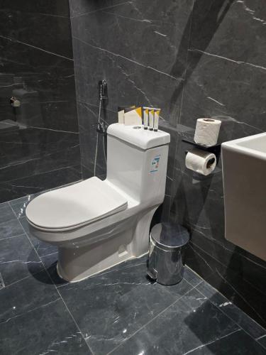 a bathroom with a white toilet and a sink at فندق فجر الواحة in Riyadh