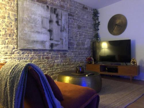 a living room with a couch and a flat screen tv at détente centre historique de MÂCON avec spa et ciné in Mâcon