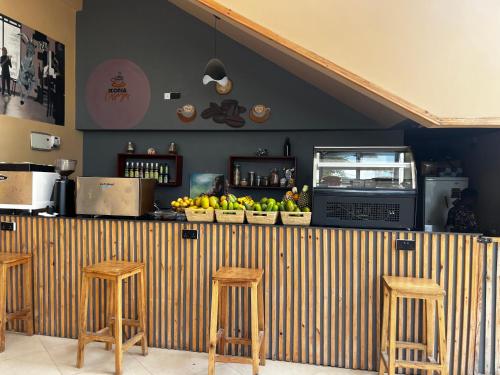 un bar avec trois tabourets et un comptoir avec des bananes dans l'établissement Resort-style living apartment, à Zanzibar City