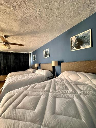 a bedroom with two beds and a ceiling at Hotel Nikché Mérida in Mérida